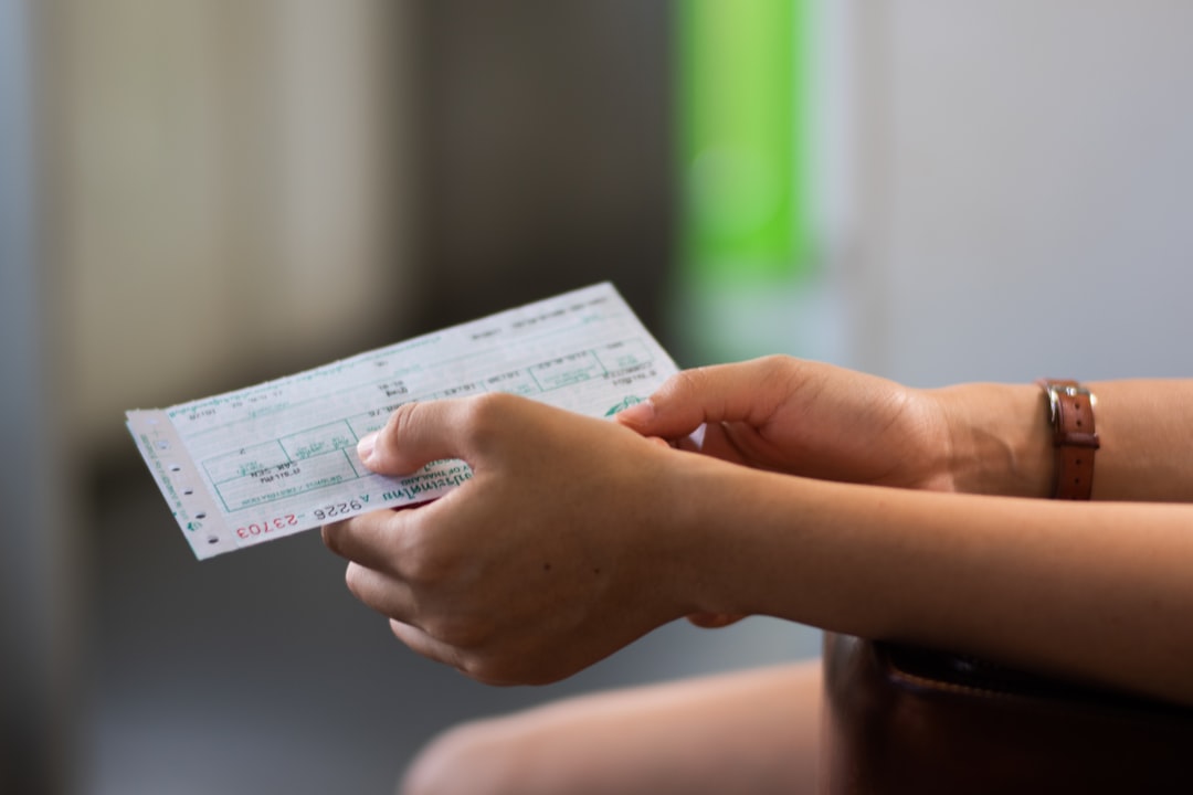 tangan memegang tiket kertas kecil sambil mengecek dengan teliti